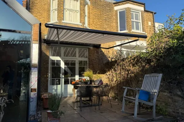 Wide view of open patio awning shading a narrow courtyard in Herne Hill.