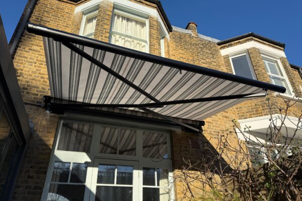 View of open Markilux stretch awning over rear courtyard patio in Herne Hill.