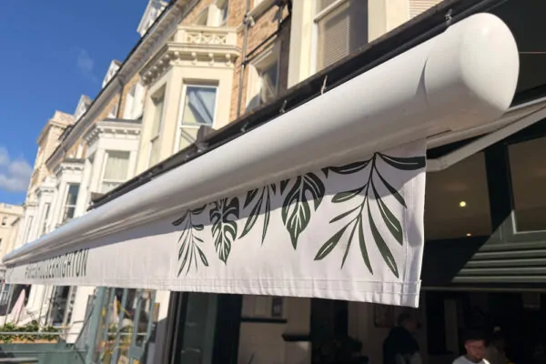 green branded awning with whit frame