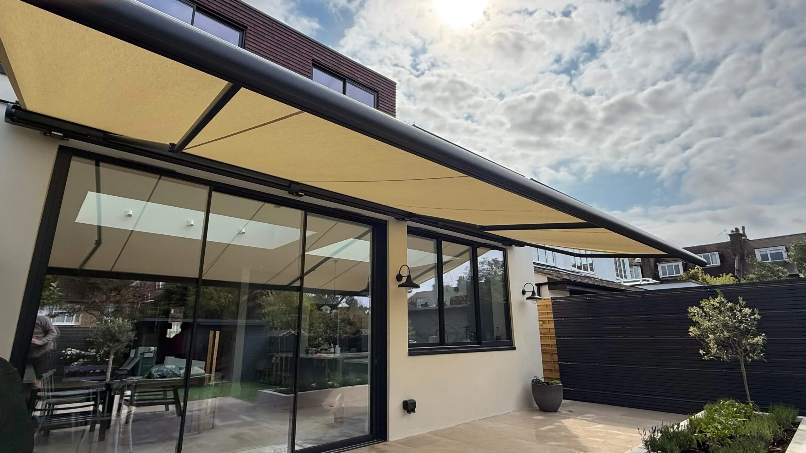 Side view of large Markilux patio awning extended across rear extension in Wandsworth Common